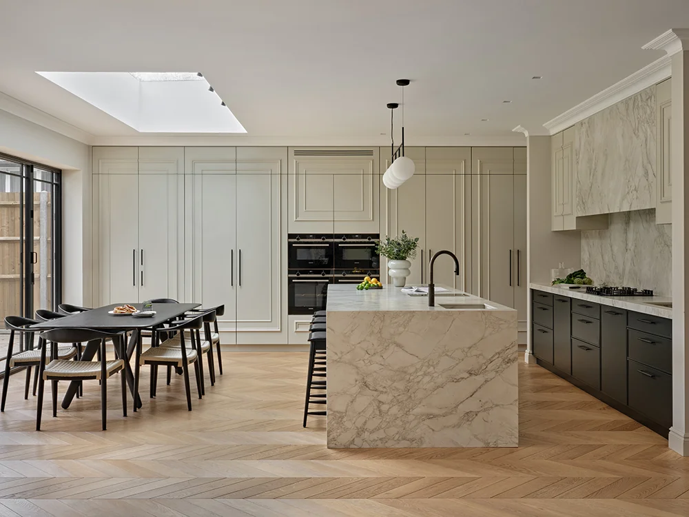 Making a Statement — A light-filled kitchen with a stone island and herringbone floor.