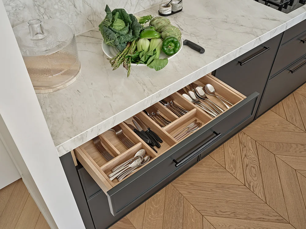 Making a Statement — Fitted cutlery storage beneath the stone worktop.