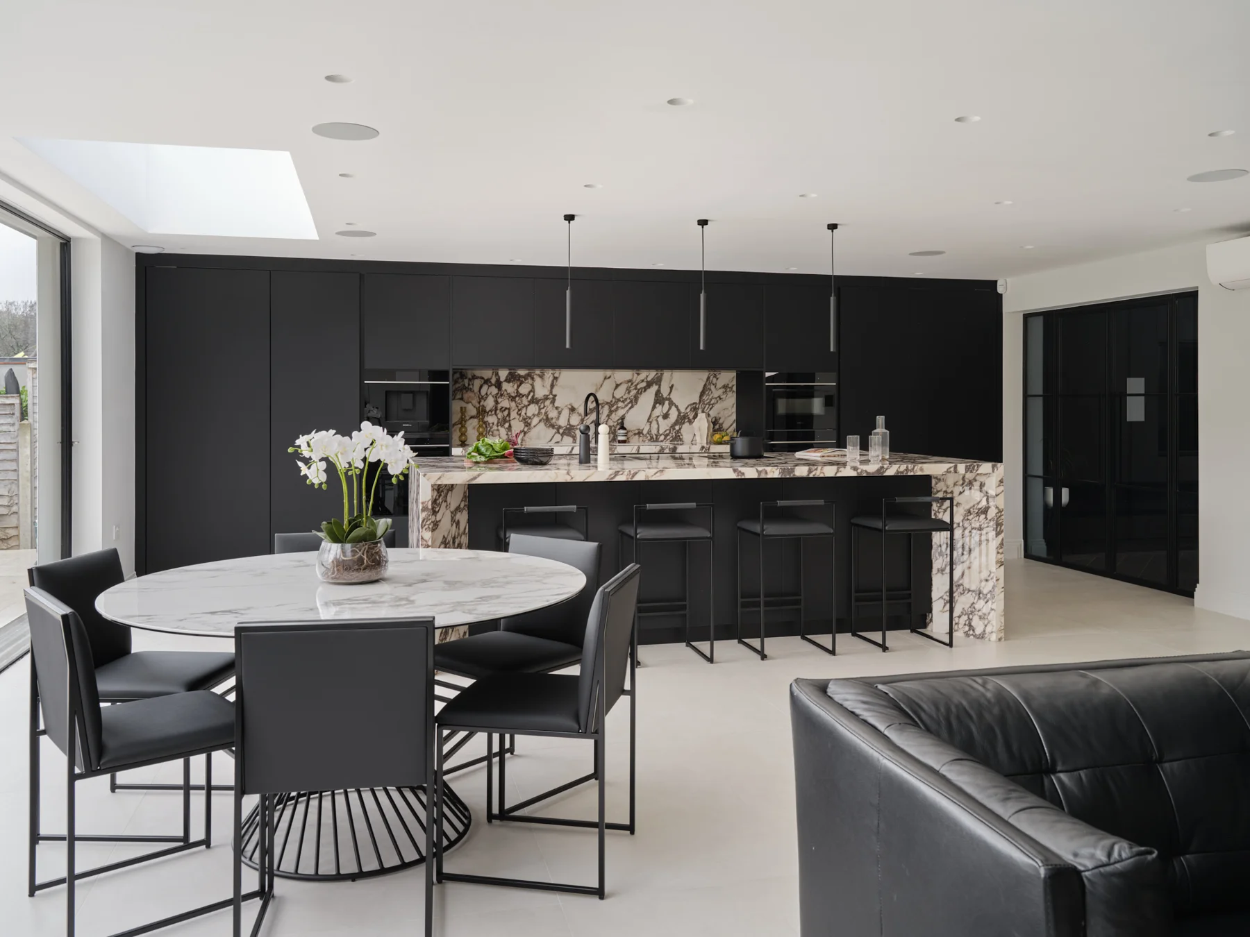 Monochrome Viola — The kitchen seen from the adjoining dining and living space.