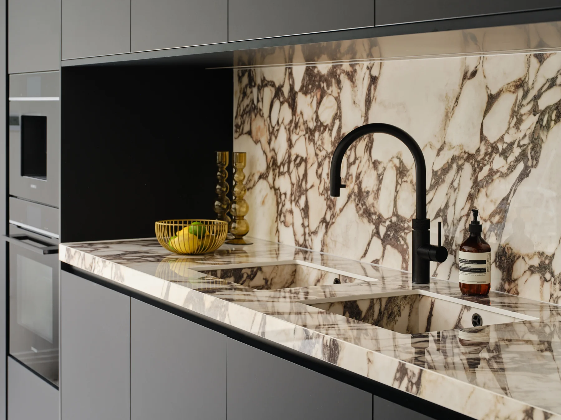Monochrome Viola — Black tap and seamless stone sink surround.