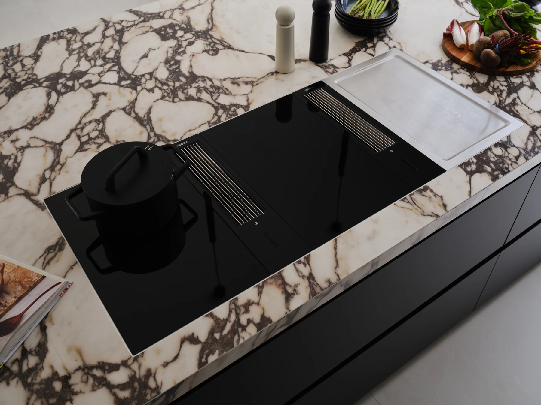Monochrome Viola — Flush black hob set within the richly veined island worktop.