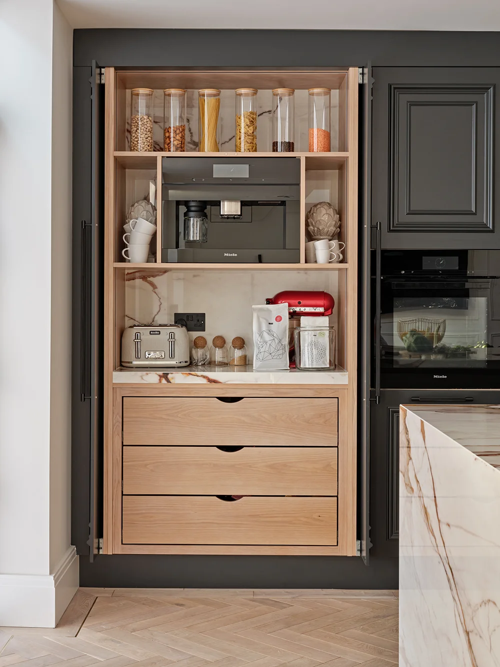 The Luxe Kitchen — Concealed breakfast station with warm timber storage.