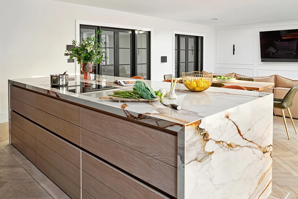 The Luxe Kitchen — Timber island drawers framed by a veined stone waterfall edge.