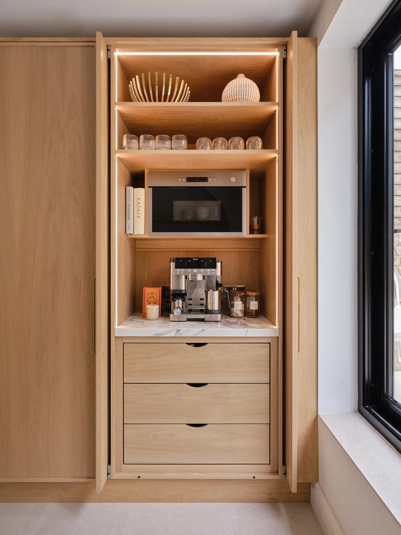 The Modern Sanctuary — Illuminated breakfast cupboard with integrated storage.